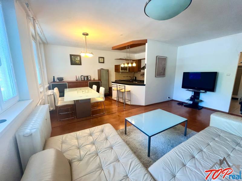 PRENÁJOM- Pekný 3 - izbový byt - Košice Staré mesto - Obývačka s kuchyňou v 3-izbovom byte, vybavenie zahŕňa sedačku, stôl a televízor.