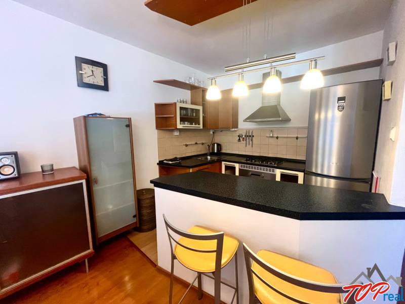 PRENÁJOM- Pekný 3 - izbový byt - Košice Staré mesto - Kuchyňa v 3-izbovom byte s barovým pultom, kovovými stoličkami a elegantnými lampami.