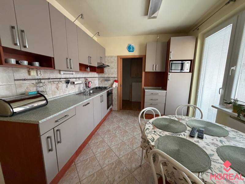 3 izbový byt  balkónom Topoľčany Juh - Kuchyňa so svetlosivými skrinkami v 3-izbovom byte, doplnená jedálenským stolom.