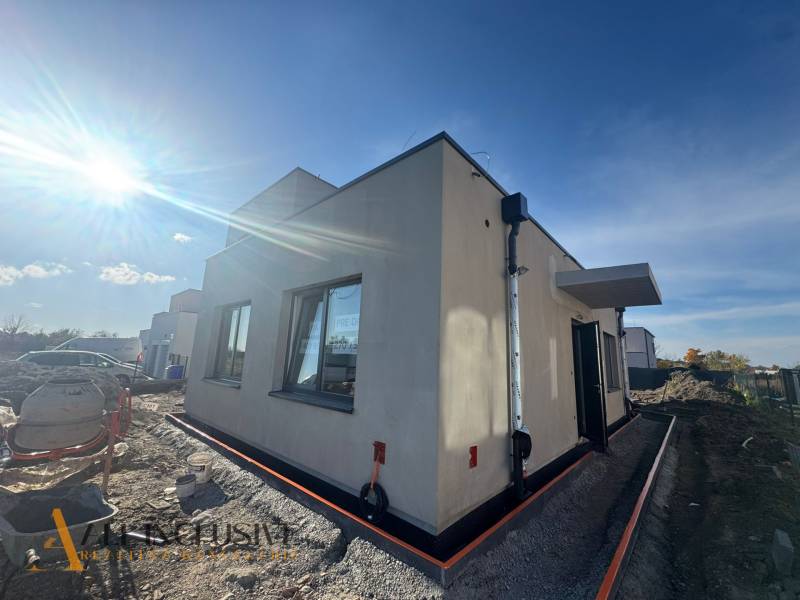 NA PREDAJ 4-IZBOVÝ RODINNÝ DOM (ČASŤ DVOJDOMU), HUBICE - Exteriér rodinného domu v Hubiciach počas výstavby, slnečné počasie zosvetľuje scénu.