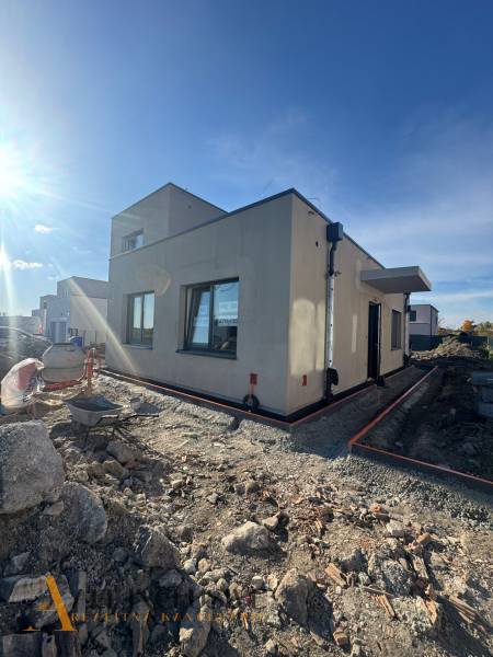 NA PREDAJ 4-IZBOVÝ RODINNÝ DOM (ČASŤ DVOJDOMU), HUBICE - Rodinný dom v Hubiciach vo výstavbe s neúpravou terénu. Jasná obloha a slnečné svetlo.