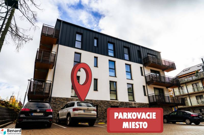 Na predaj krásny apartmám v Štrbe - Bytový dom na Lúčnej ulici v Štrbe s vyznačeným parkovacím miestom v popredí.