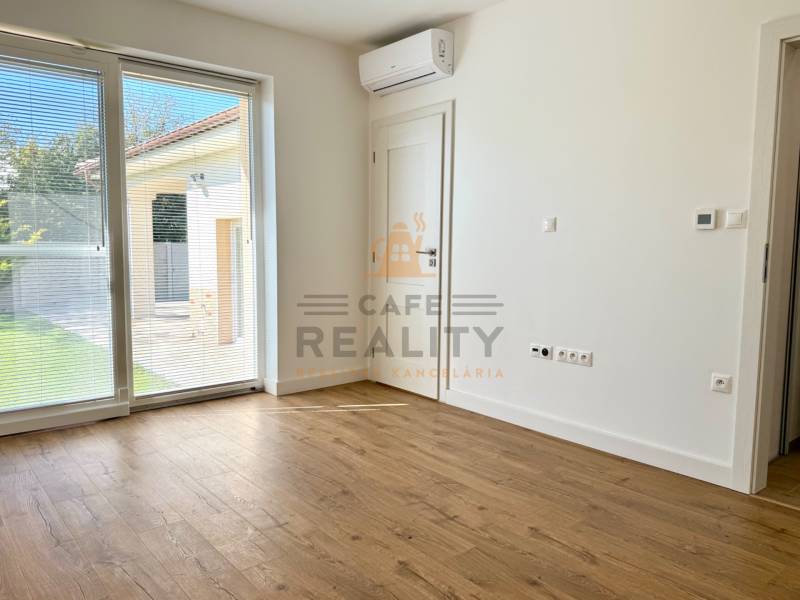 REZERVOVANÉ Na prenájom 4 izbový rodinný dom, Pata, ul. Pod Vinohradmi - Izba s klimatizáciou a veľkým oknom, podlaha s dreveným dekorom v rodinnom dome.