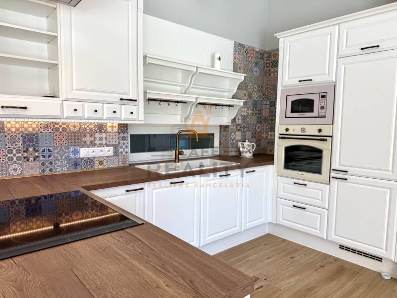 REZERVOVANÉ Na prenájom 4 izbový rodinný dom, Pata, ul. Pod Vinohradmi - Kuchyňa v rodinnom dome s podlahou s dreveným dekorom a vzorovaným obkladom.