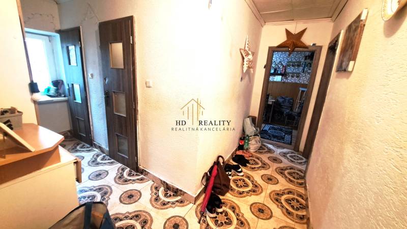 HD reality, Predaj 2-izbového bytu, Veľký Krtíš - Chodba v 2-izbovom byte s dekoratívnou dlažbou a nábytkom.