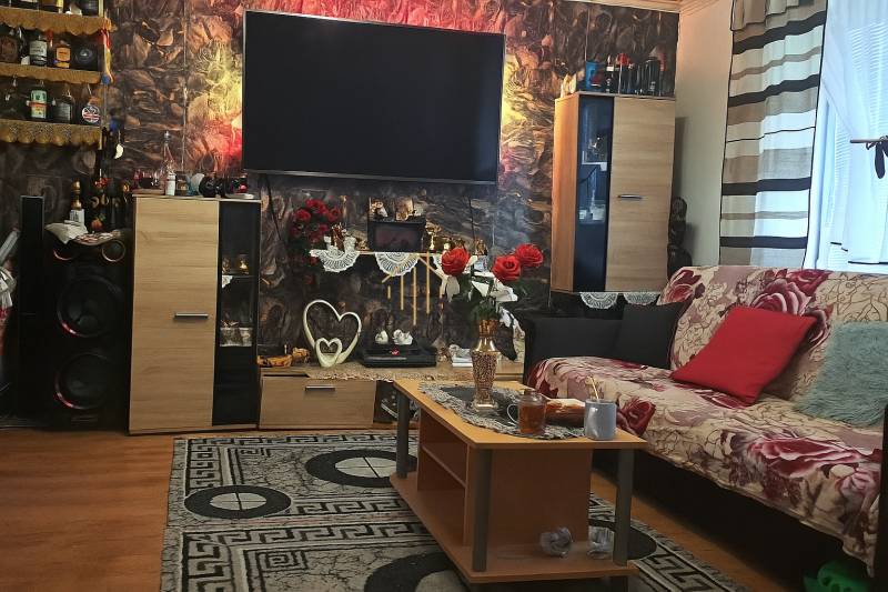 HD reality, Predaj 2-izbového bytu, Veľký Krtíš - Obývacia izba v 2-izbovom byte s dekoratívnymi prvkami a podlahou s dreveným dekorom.