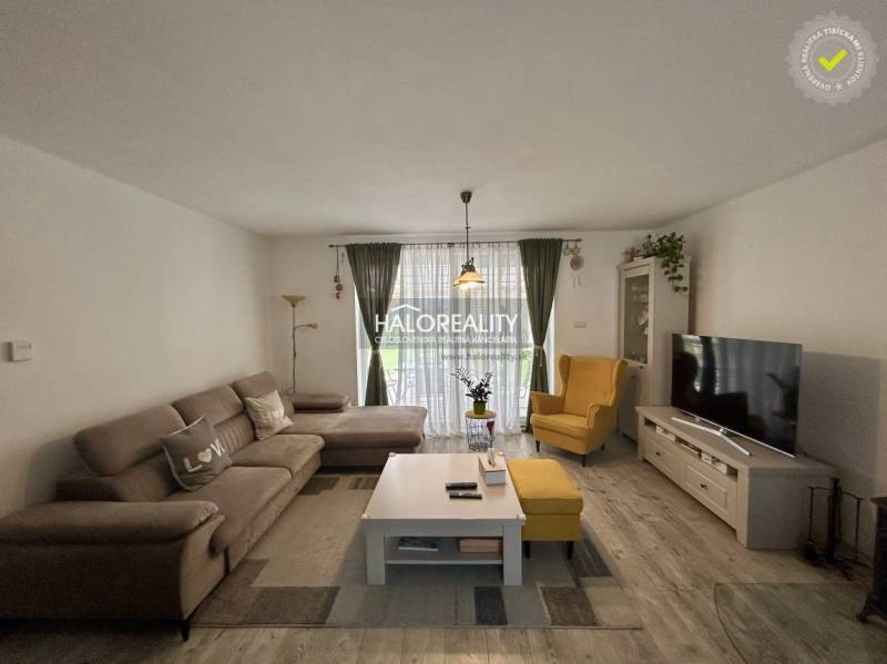 REZERVOVANÉ - Predaj, rodinný dom Malinová - NOVOSTA... - Obývačka v rodinnom dome so sedačkou, kreslom, televízorom a kvetmi.