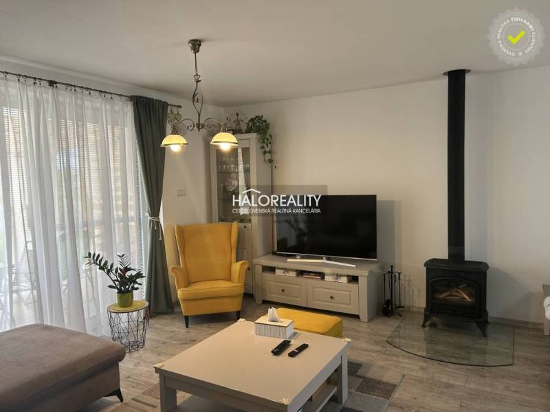 REZERVOVANÉ - Predaj, rodinný dom Malinová - NOVOSTA... - Obývacia izba v rodinnom dome s krbom, žltým kreslom a televízorom.