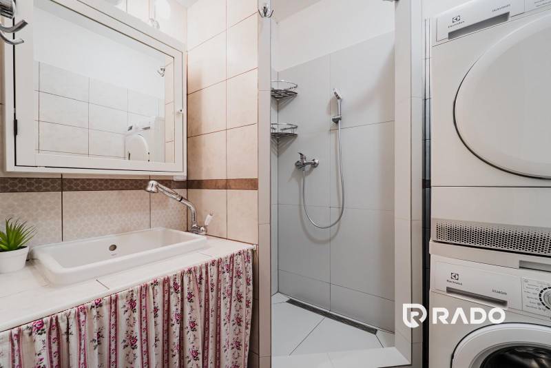 VÝBORNÁ CENA  3 izbový byt Armádna ulica v Trenčíne  - Kúpeľňa v 3-izbovom byte s práčkou, sprchovým kútom a umývadlom so závesom.