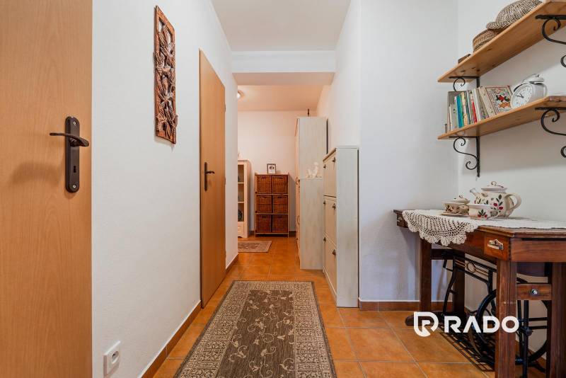 VÝBORNÁ CENA  3 izbový byt Armádna ulica v Trenčíne  - Predsieň v 3-izbovom byte s dlažbou, drevenou poličkou a dekoratívnymi predmetmi.