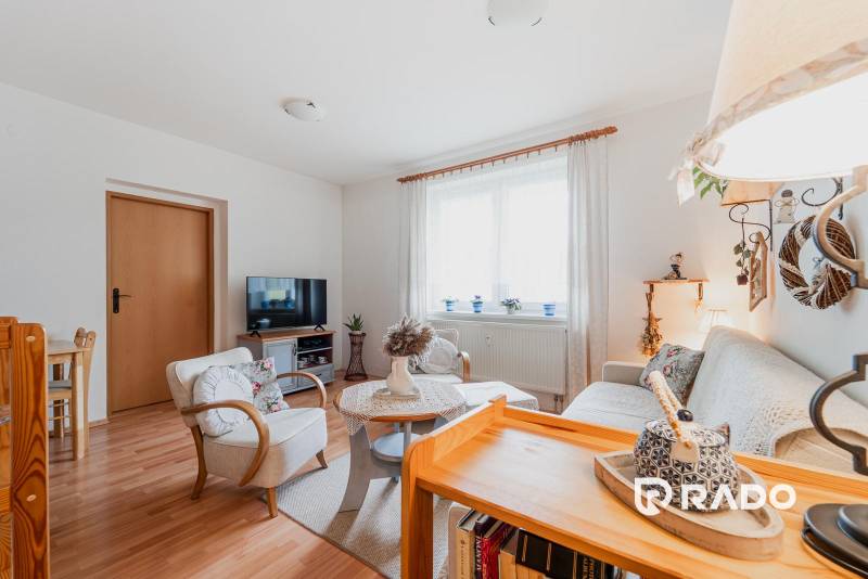 VÝBORNÁ CENA  3 izbový byt Armádna ulica v Trenčíne  - Obývačka 3-izbového bytu s pohodlným nábytkom a podlahou s dreveným dekorom.