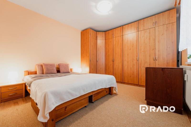 VÝBORNÁ CENA  3 izbový byt Armádna ulica v Trenčíne  - Spálňa v 3-izbovom byte s posteľou, vstavanou skriňou a podlahou s dreveným dekorom.