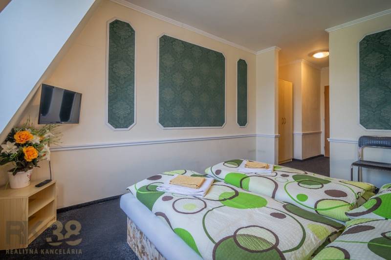 Predaj nehnuteľnosti v mestskej časti Poprad-Veľká - Izba v hoteloch a penziónoch s dvomi posteľami, televízorom a kvetmi na stolíku.