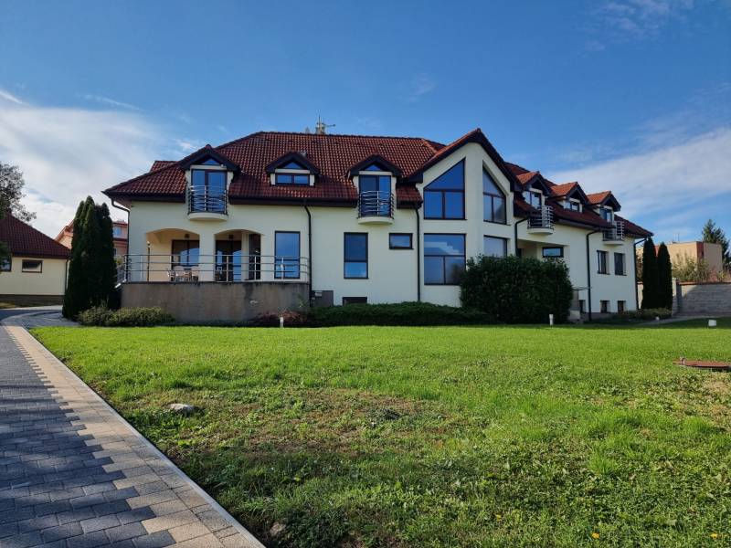 EXKLUZÍVNA VILA - NITRA - PREDAJ - Rodinný dom na Dolnočermánskej ulici v Nitre s upraveným trávnikom a terasou.