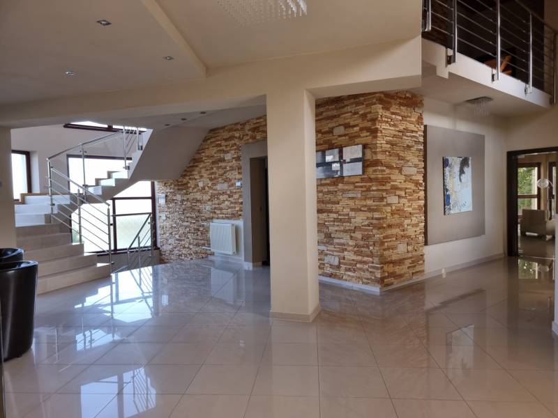 EXKLUZÍVNA VILA - NITRA - PREDAJ - Interiér rodinného domu s keramickou dlažbou, kamenným obkladom a moderným schodiskom.