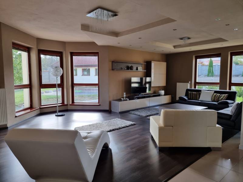 EXKLUZÍVNA VILA - NITRA - PREDAJ - Obývacia izba v rodinnom dome s pohodlným sedením a veľkými oknami.