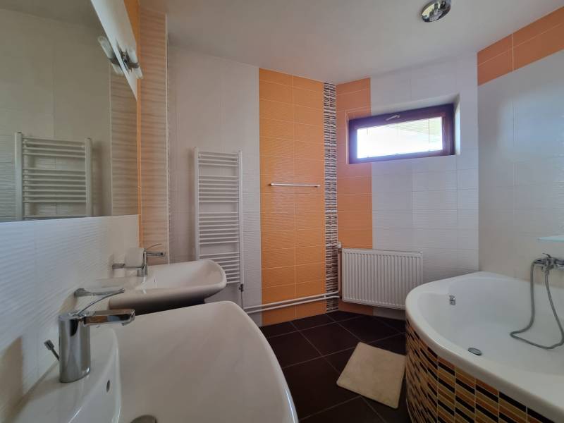 EXKLUZÍVNA VILA - NITRA - PREDAJ - Kúpeľňa v rodinnom dome so sprchou, vaňou a zrkadlom, svetlé dlaždice a okno.