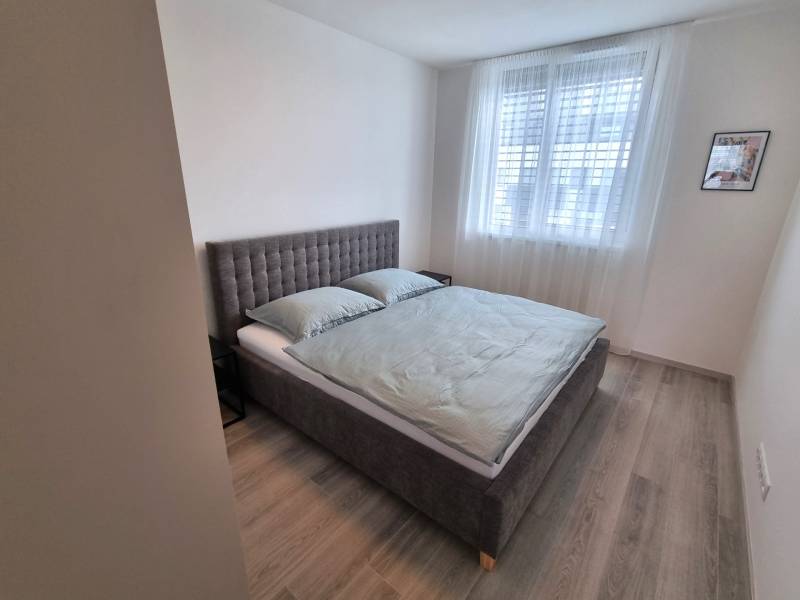 PRENÁJOM - 3 izbový byt Nitra – RIVIERA NITRA, Piesková ulica - Spálňa so sivou posteľou a svetlým nábytkom v 3-izbovom byte.