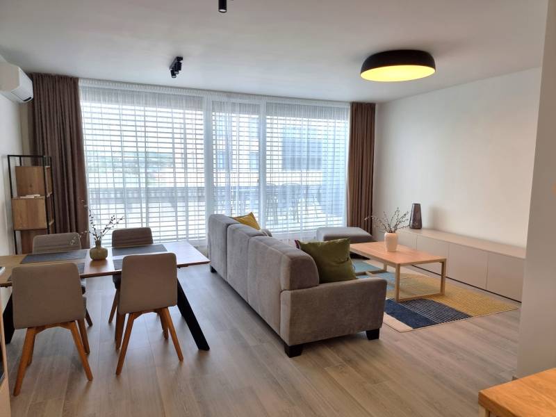 PRENÁJOM - 3 izbový byt Nitra – RIVIERA NITRA, Piesková ulica - Obývacia izba 3-izbového bytu s jedálenským stolom, sedačkou a veľkými oknami.