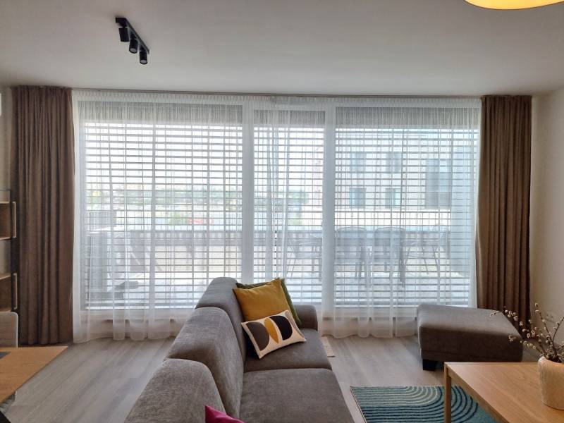 PRENÁJOM - 3 izbový byt Nitra – RIVIERA NITRA, Piesková ulica - Obývacia izba v 3-izbovom byte s pohodlnou sedačkou a veľkými oknami.