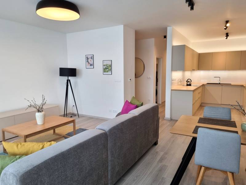 PRENÁJOM - 3 izbový byt Nitra – RIVIERA NITRA, Piesková ulica - Obývacia časť 3-izbového bytu so sivou sedačkou a kuchynským kútom.