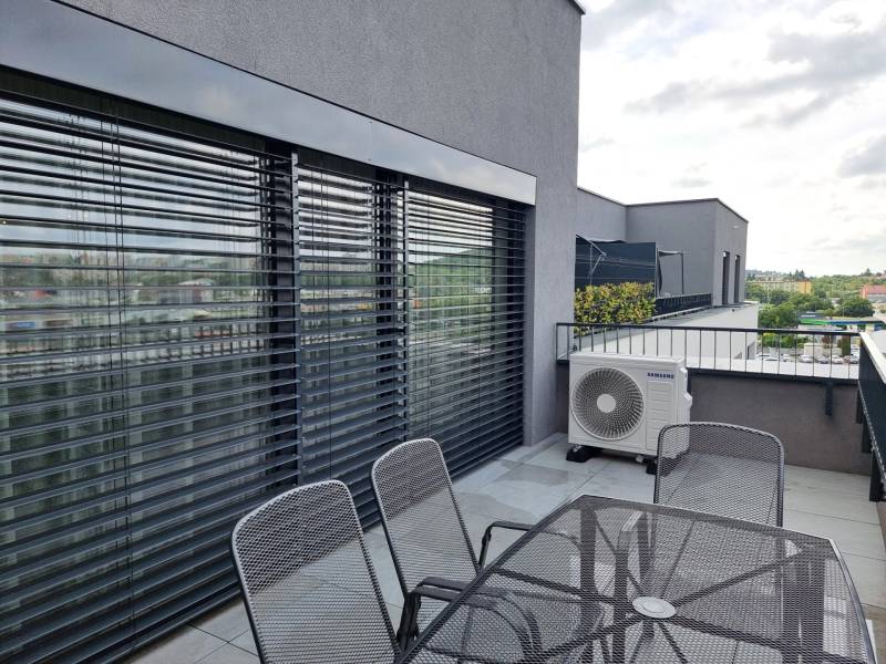 PRENÁJOM - 3 izbový byt Nitra – RIVIERA NITRA, Piesková ulica - Terasa 3-izbového bytu na Pieskovej ulici v Nitre s vonkajším posedením a žalúziami.