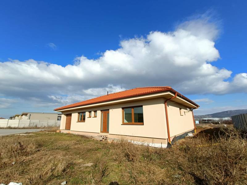 PREDAJ - 4 izbový holodom s veľkou garážou , Lužianky, Smreková ulica - Rodinný dom s hnedou strechou v prírodnom prostredí pod modrou oblohou.