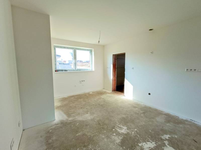 PREDAJ - 4 izbový holodom s veľkou garážou , Lužianky, Smreková ulica - Prázdna miestnosť s veľkým oknom, pripravená na dokončenie v rodinnom dome.