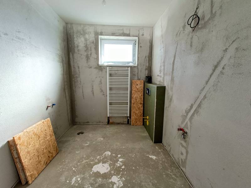 PREDAJ - 4 izbový holodom s veľkou garážou , Lužianky, Smreková ulica - Rozostavaná miestnosť s betónovou podlahou, oknom, radiátorom v rodinnom dome.