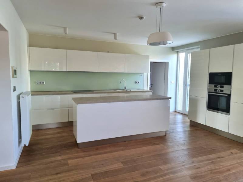 PREDAJ - 3 izbový dom v centre mesta, Nitra - Kuchyňa v rodinnom dome s bielymi skrinkami a podlahou s dreveným dekorom.