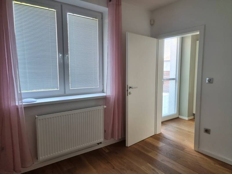 PREDAJ - 3 izbový dom v centre mesta, Nitra - Izba v rodinnom dome s podlahou s dreveným dekorom, oknom a závesmi.