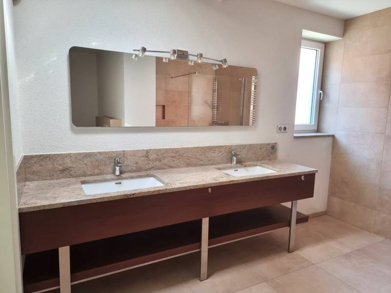 PREDAJ - 3 izbový dom v centre mesta, Nitra - Rodinný dom s dvoma umývadlami, zrkadlom, oknom a podlahou s dreveným dekorom.