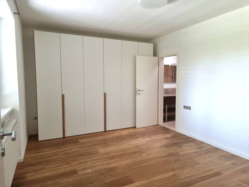 PREDAJ - 3 izbový dom v centre mesta, Nitra - Spálňa v rodinnom dome s bielymi skriňami a podlahou s dreveným dekorom.