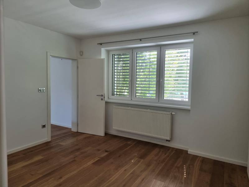 PREDAJ - 3 izbový dom v centre mesta, Nitra - Izba v rodinnom dome s podlahou s dreveným dekorom a veľkým oknom.