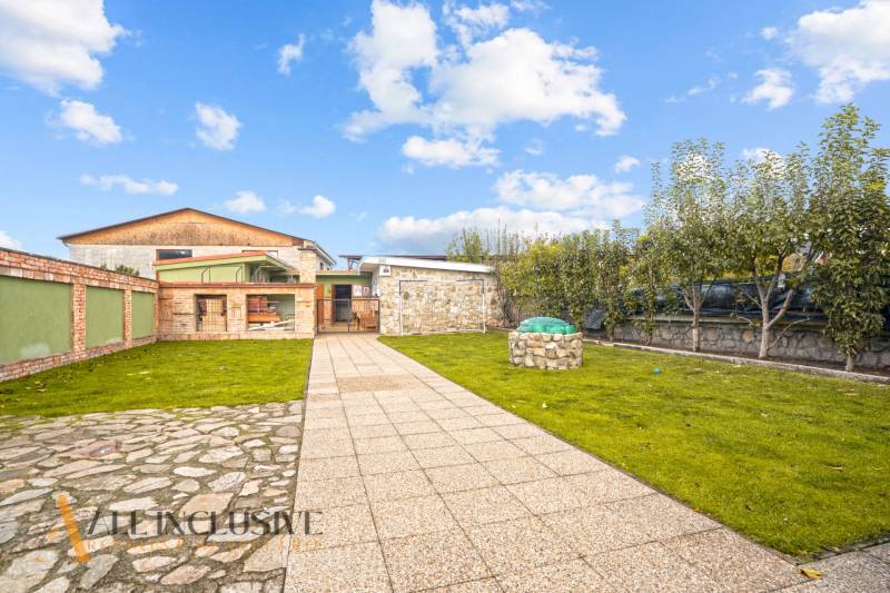 NA PREDAJ 5+2 IZBOVÝ RD PRI KÚPALISKU, DUNAJSKÁ STREDA - Záhrada pri rodinnom dome na Kúpeľnej ulici v Dunajskej Strede s trávnikom a dlažbou.