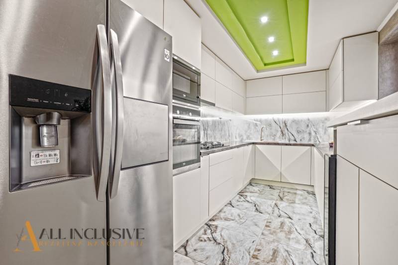 NA PREDAJ 5+2 IZBOVÝ RD PRI KÚPALISKU, DUNAJSKÁ STREDA - Kuchyňa v rodinnom dome s bielymi skrinkami, mramorovou zástavou a nerezovou chladničkou.