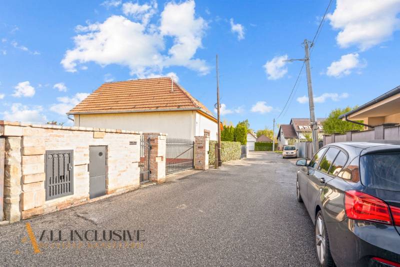 NA PREDAJ 5+2 IZBOVÝ RD PRI KÚPALISKU, DUNAJSKÁ STREDA - Rodinný dom na Kúpeľnej ulici v Dunajskej Strede obklopený autami a oplotením.