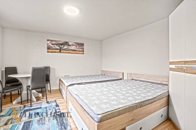 NA PREDAJ 5+2 IZBOVÝ RD PRI KÚPALISKU, DUNAJSKÁ STREDA - Spálňa v rodinnom dome s dvomi posteľami, skriňou a podlahou s dreveným dekorom.