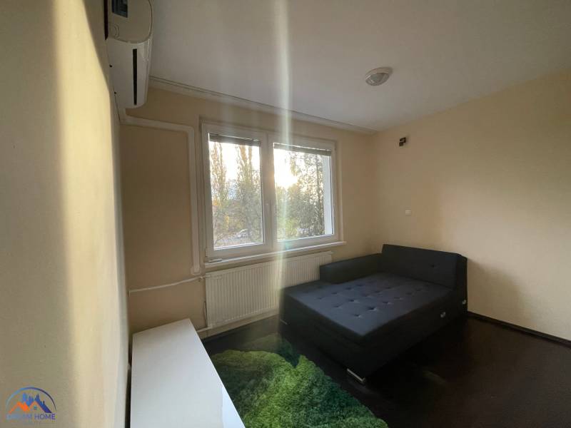 MH279-Na predaj 1 izbový byt v oblúbenej lokalite Komárna! - Jednoduchá izba s posteľou, kobercom a oknom v 1-izbovom byte.