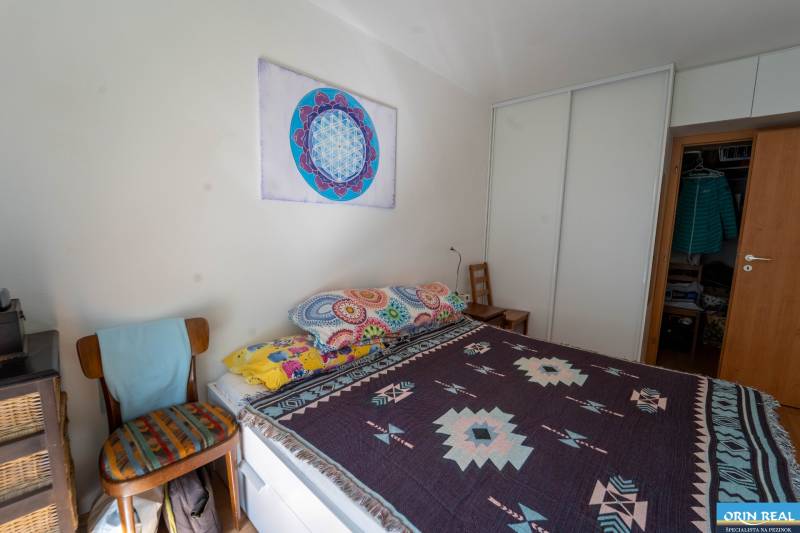 Na predaj útulný 2 izbový byt so zahradkou Svätý Jur 165.000,- Eur - Spálňa v 2-izbovom byte s farebnými prikrývkami a vstavaným šatníkom.