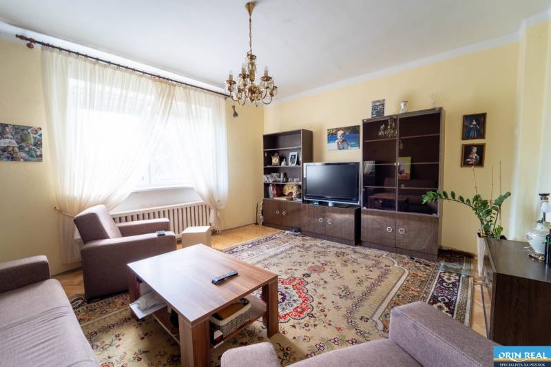 Na predaj rodinný dom s rozľahlým pozemkom 1788m2 MODRA - Obývacia izba v rodinnom dome s pohovkou, konferenčným stolíkom, skrinkami a televízorom.