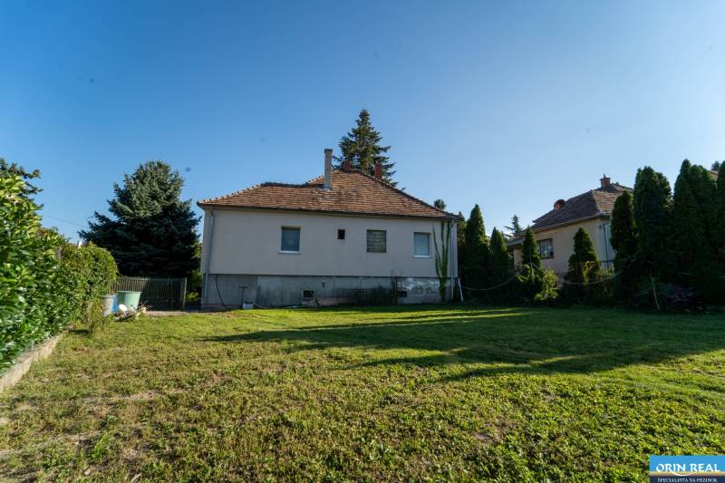 Na predaj rodinný dom s rozľahlým pozemkom 1788m2 MODRA - Rodinný dom na Podhorskej ulici v Modre s trávnatou záhradou a stromami.