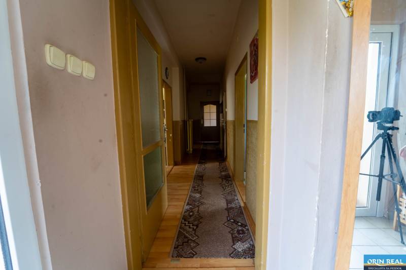 Na predaj rodinný dom s rozľahlým pozemkom 1788m2 MODRA - Chodba v rodinnom dome s podlahou s dreveným dekorom a behúňom.