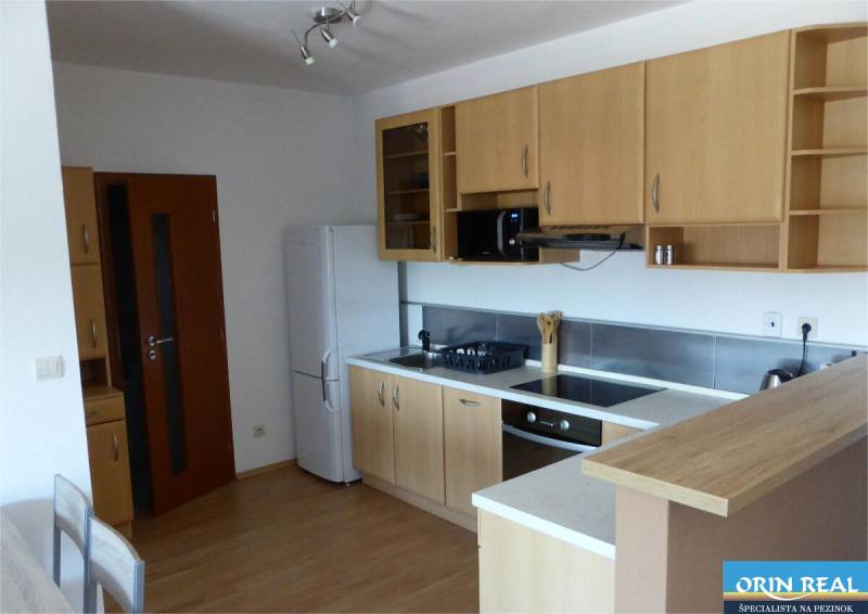 Na predaj 2 izbový byt s parkovacím státím Zemplínska ul. - Kuchyňa so svetlými skrinkami a podlahou s dreveným dekorom v 2-izbovom byte.