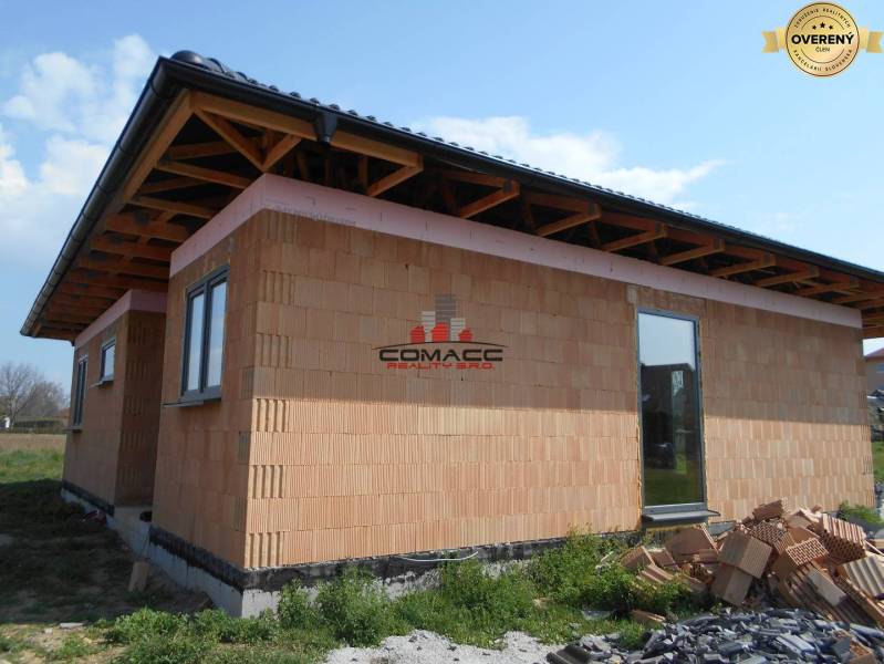 Výstavba inteligentného 4 izbového bungalovu v NM a okolí - Rodinný dom v Novom Meste nad Váhom, zobrazuje rozostavanú stavbu s tehlovou fasádou.