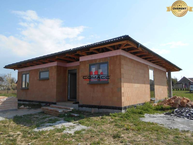 Výstavba inteligentného 4 izbového bungalovu v NM a okolí - Rodinný dom v Novom Meste nad Váhom počas výstavby, obklopený trávnatým pozemkom.