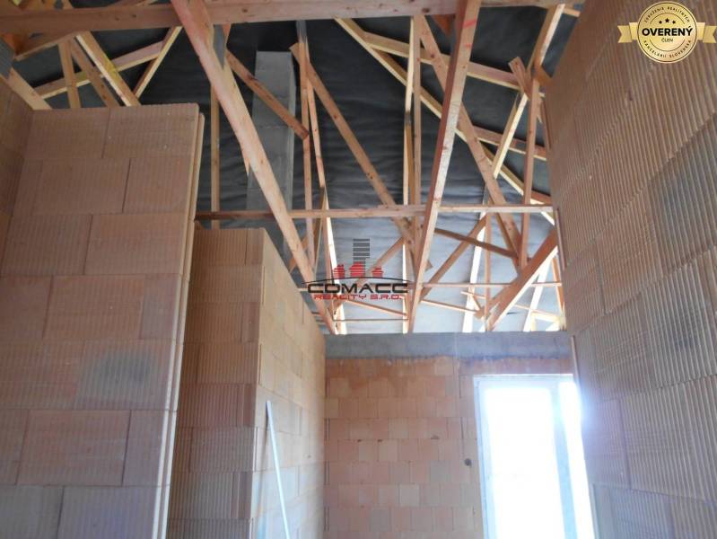 Výstavba inteligentného 4 izbového bungalovu v NM a okolí - Stavba interiéru rodinného domu na ulici Nové Mesto nad Váhom s drevenými trámami.