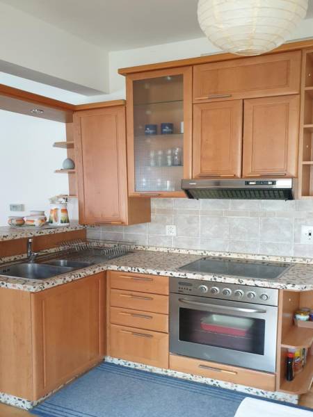 Novinka: Praktický byt v širšom centre. Mestská ul. Províziu neplatíte - Kuchyňa v 2-izbovom byte s dreveným dekorom, nerezovým drezom a rúrou na pečenie.