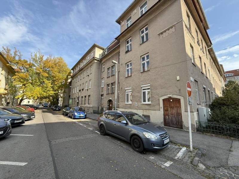 Novinka: Praktický byt v širšom centre. Mestská ul. Províziu neplatíte - Ulica Mestská v Bratislave - Nové Mesto s obytnou budovou a zaparkovanými autami.