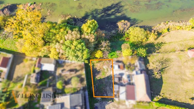 NA PREDAJ STAVEBNÝ POZEMOK, JAHODNÁ - Letecký pohľad na pozemok v Jahodnej určený na bývanie, obklopený zeleňou blízko vody.